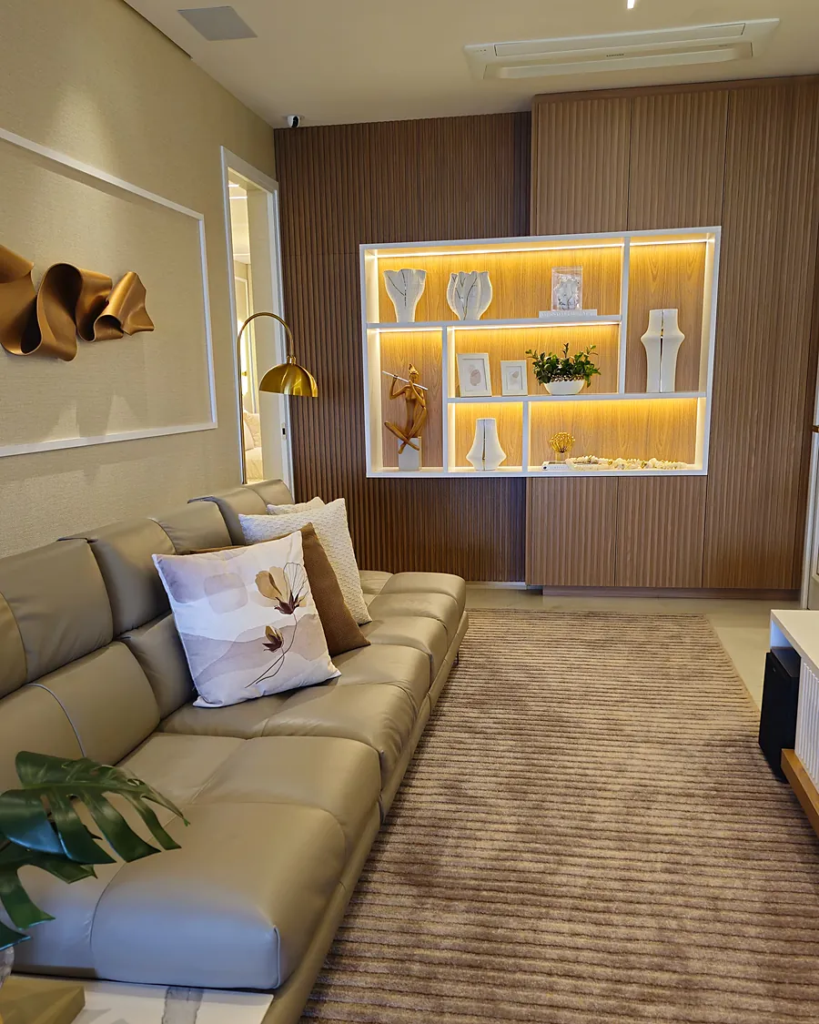 Sala de TV com nicho iluminado e painel em madeira