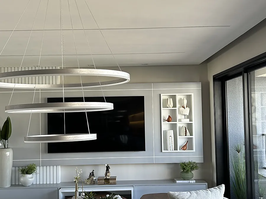 Sala com painel, nichos e lustre de anéis